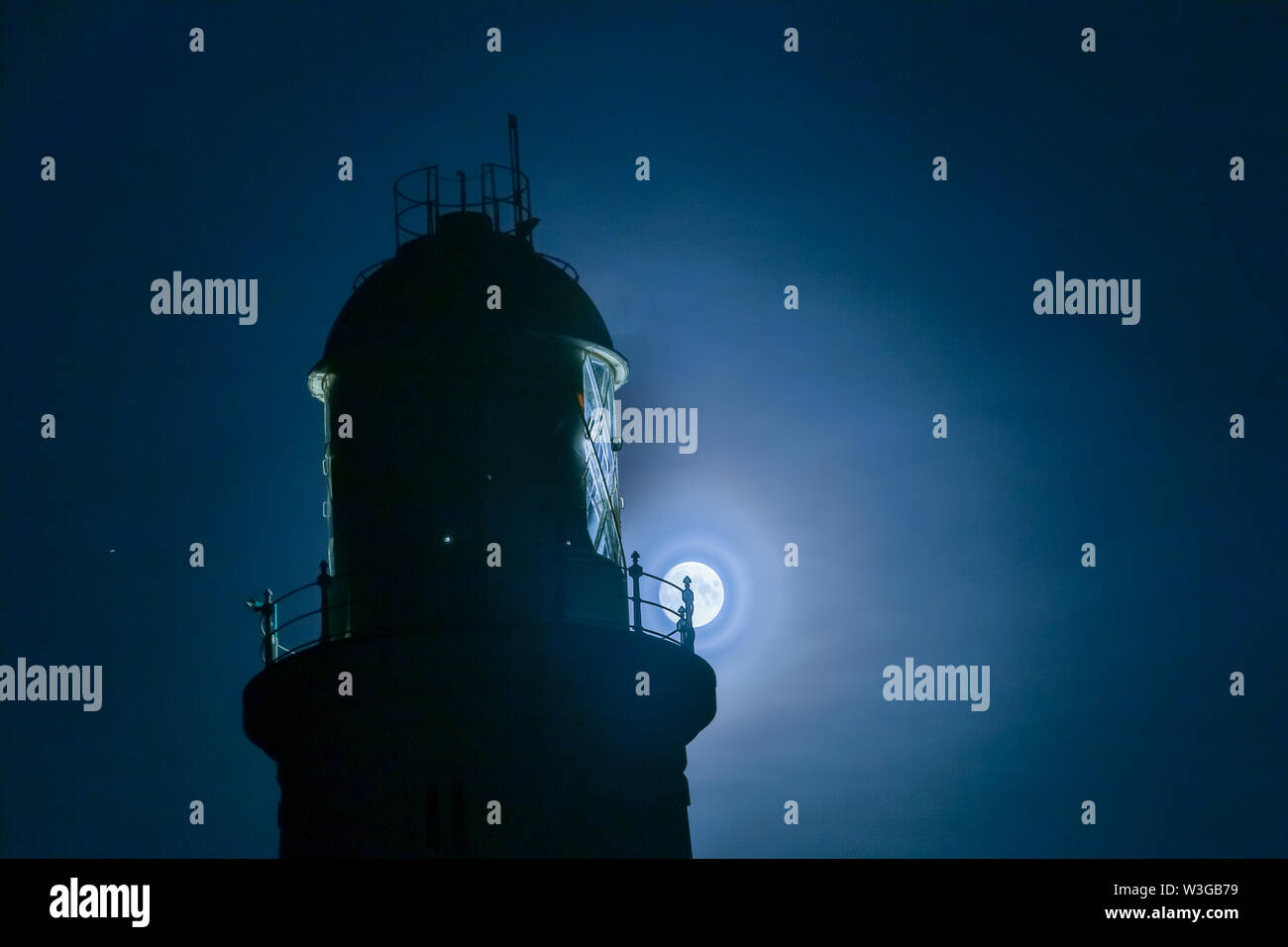 Portland, Dorset, Großbritannien. Am 15. Juli 2019. Der Mond steigt hinter der Leuchtturm von Portland Bill, Dorset. Der Vollmond im Juli ist als 'Buck Moon' bekannt. Peter Lopeman/Alamy leben Nachrichten Stockfoto