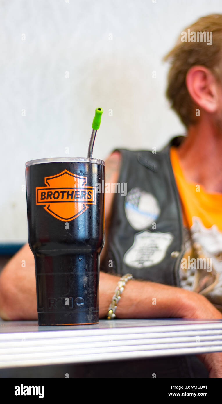 Nahaufnahme von custom made Black Metal Travel Mug Tasse mit orange Harley-Davidson Emblem mit Brüdern das Wort'' eingerichtet. Metall Tischkante in Diner. Stockfoto
