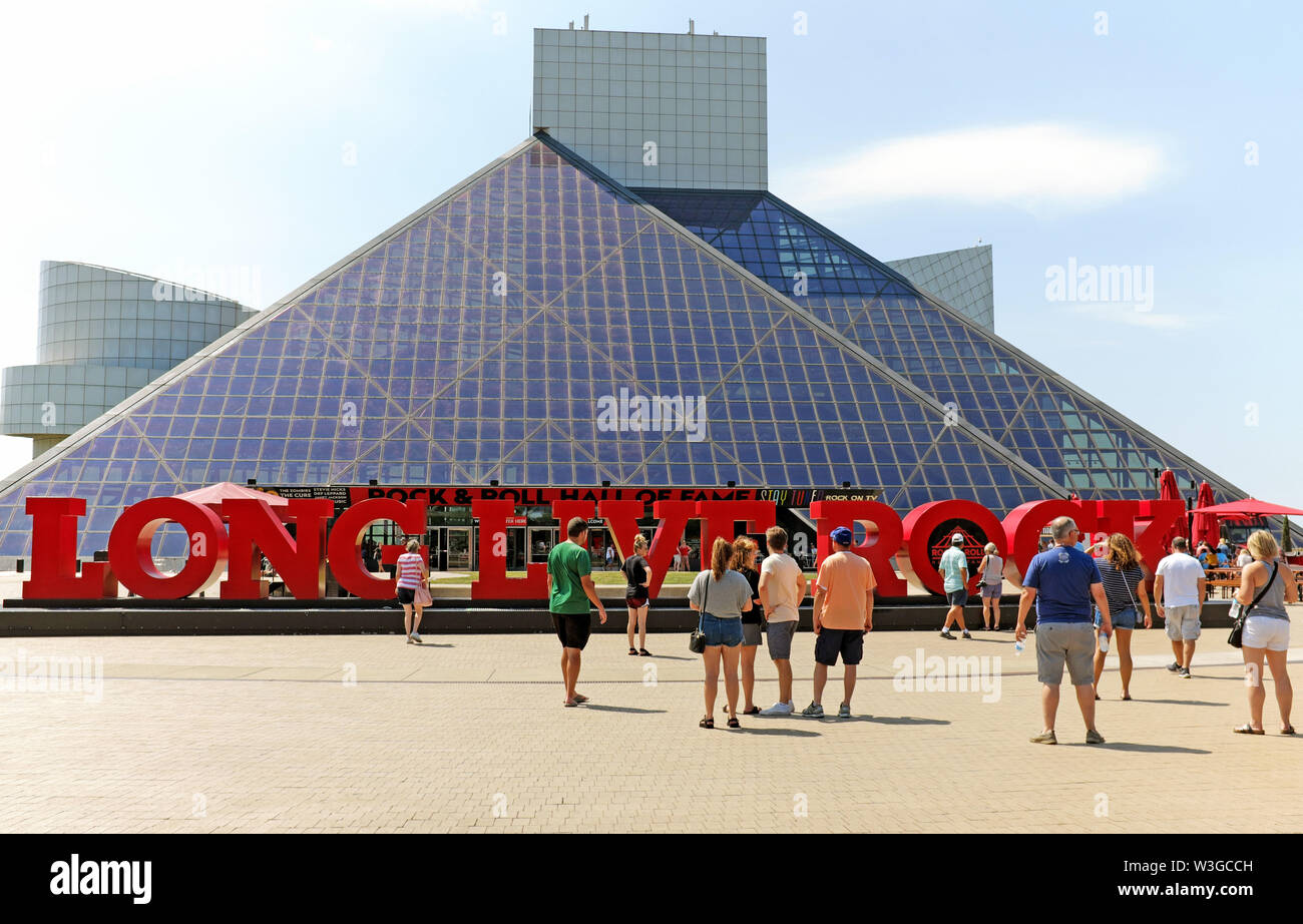 Besucher genießen Sie einen Sommertag an der Cleveland Rock and Roll Hall of Fame und Museum in der Innenstadt von Cleveland, Ohio, USA. Stockfoto