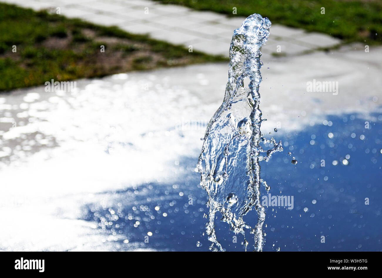 Brunnen mit einem Wasserstrahl und bokeh Hintergrund 2019-06-15 Dragon, Umea, Schweden Stockfoto