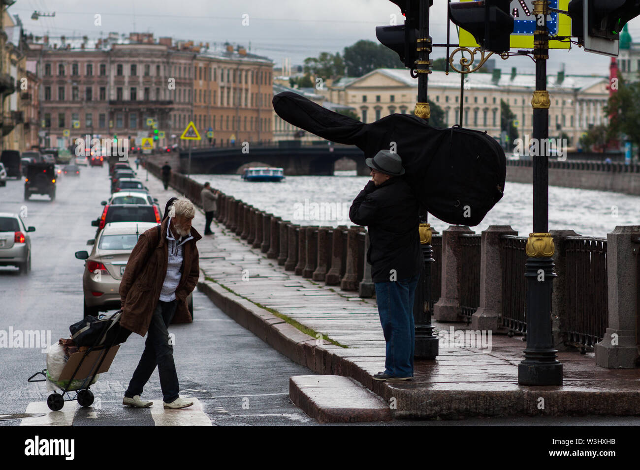 SAINT-Petersburg, Russland - Juli,22 2015: Obdachlose alte Mann mit Warenkorb und Musiker mit Instrument. Stockfoto