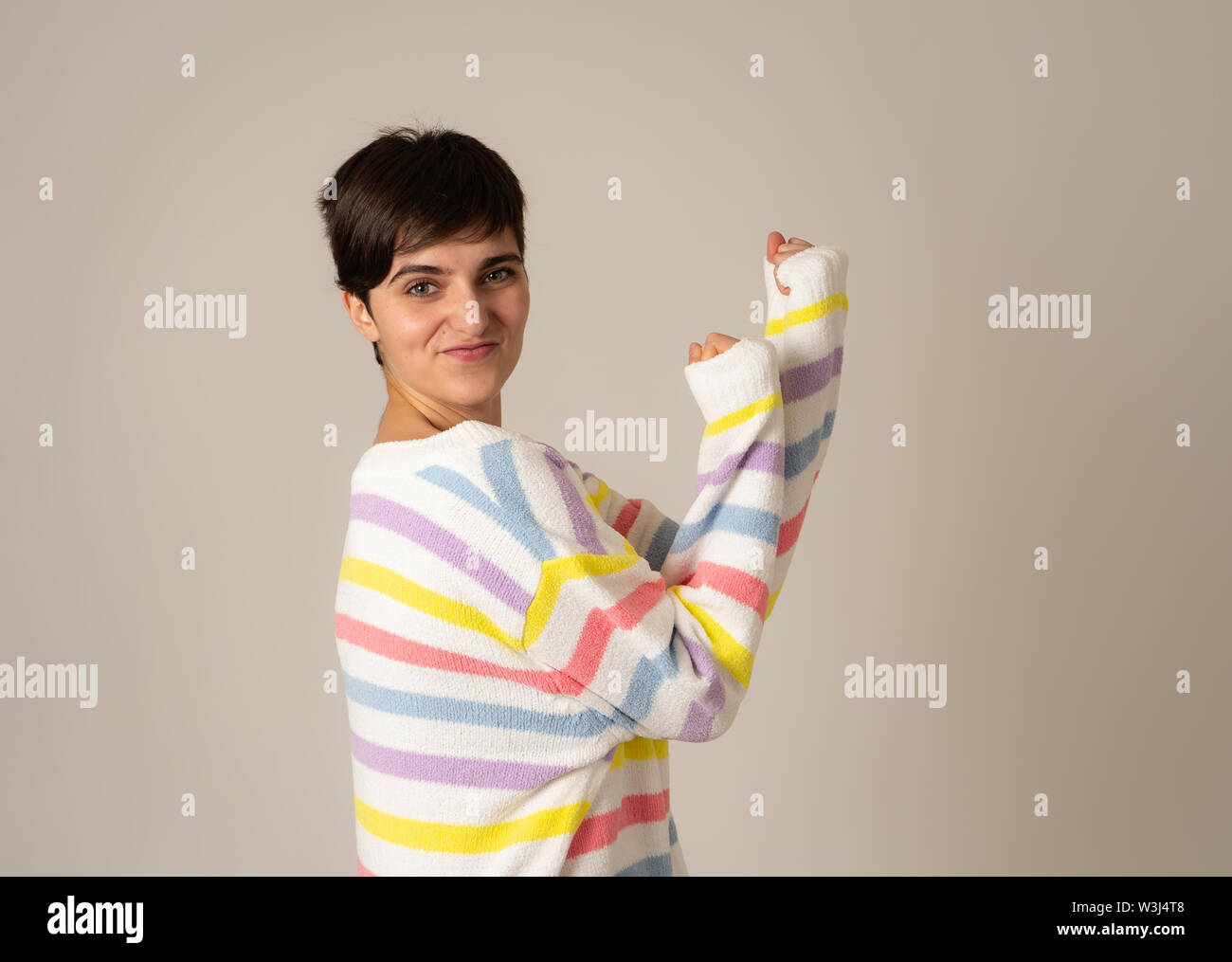 Portrait von glücklichen jungen kaukasischen Frauen lachen und Spaß in grün gestreiften Pullover in neutralen Hintergrund isoliert. Die Menschen, die menschliche positive Stockfoto Portrait von glücklichen jungen kaukasischen Frauen lachen und Spaß in grün gestreiften Pullover in neutralen Hintergrund isoliert. Die Menschen, die menschliche positive Stockfoto