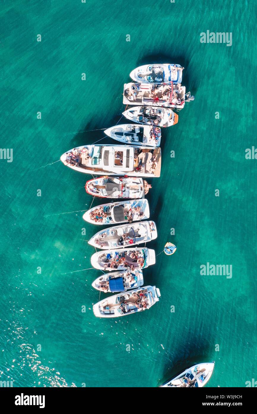 Vertikale Aufnahme von Booten verschiedener Größe, die in der Nähe angedockt sind Einander in einer Reihe auf dem Wasser Stockfoto