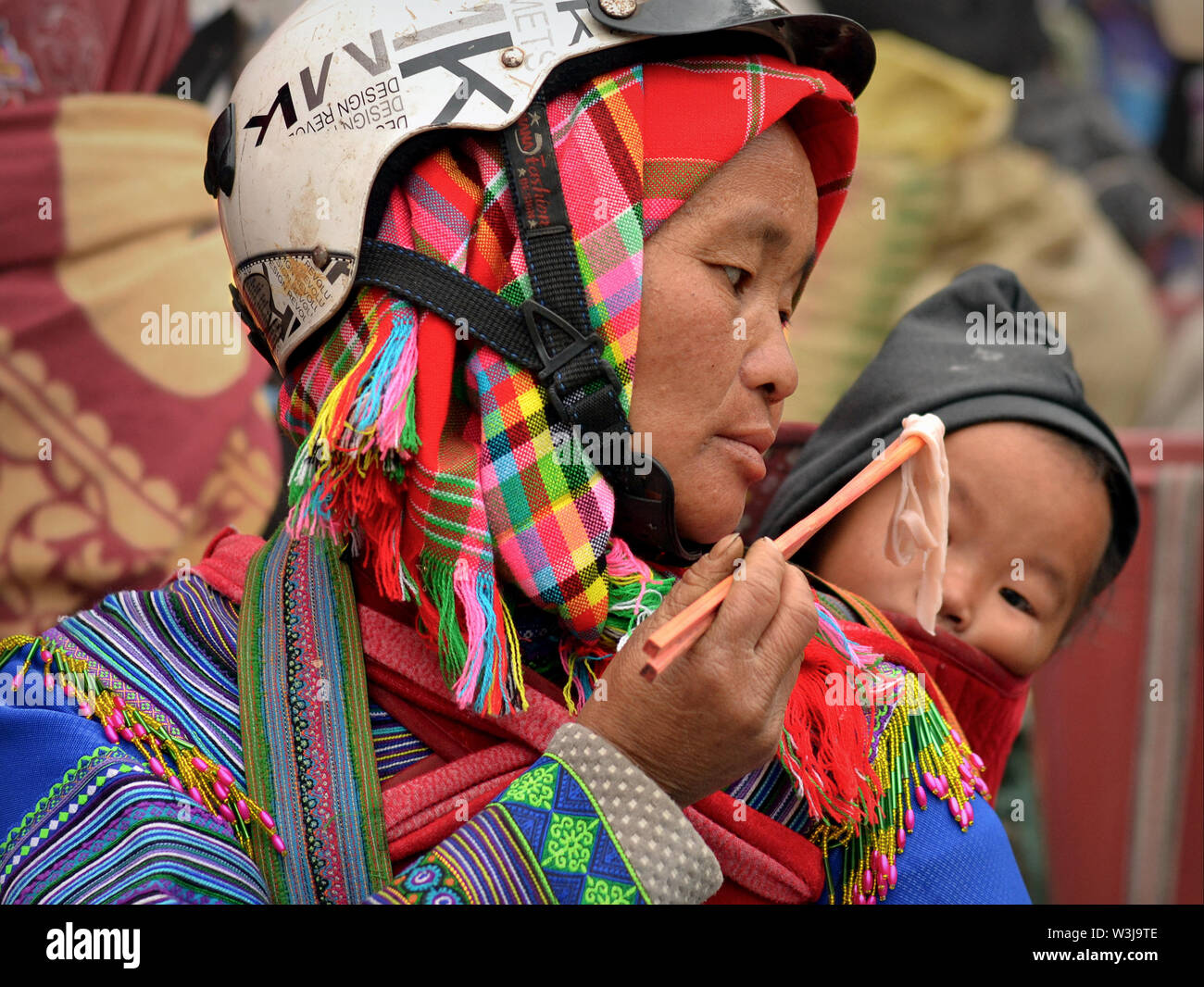 Vietnamesische H'Mong Bergvolk Frau in tribal Kleidung feeds Flachbild Reisnudeln auf Ihr süsses Baby. Stockfoto