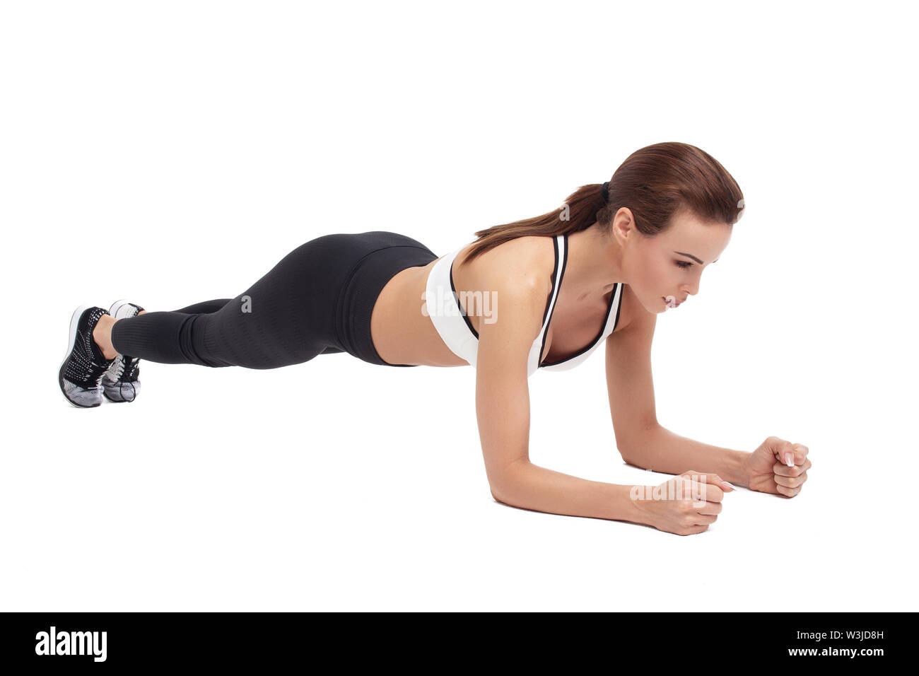 Junge passende Frau in Sportkleidung, Plank, isoliert auf weißem Stockfoto