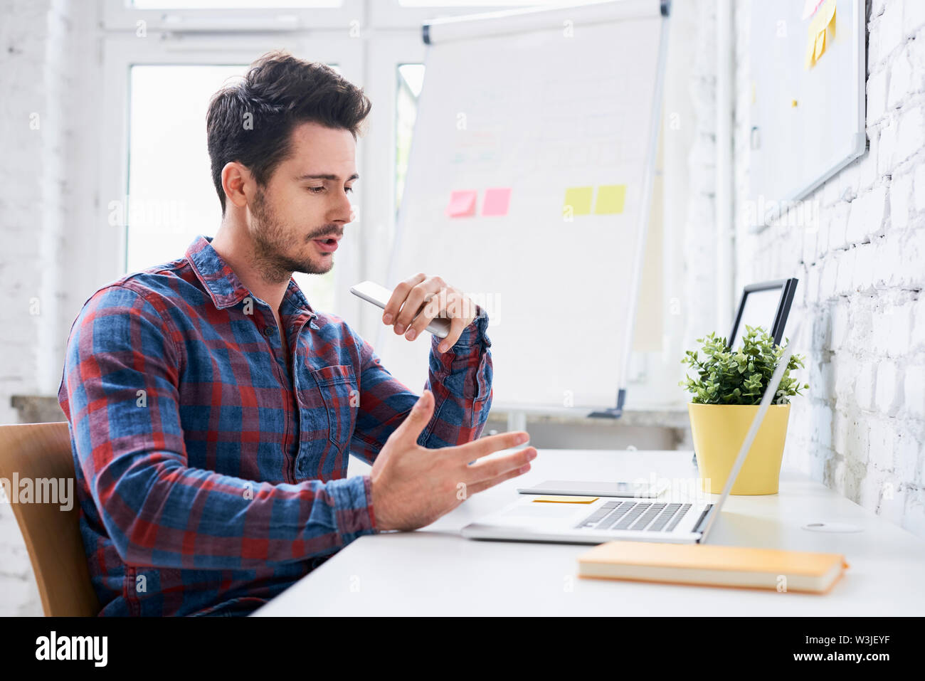 Junge startup Unternehmer am Telefon sprechen mit Client beim Sitzen im Büro Stockfoto