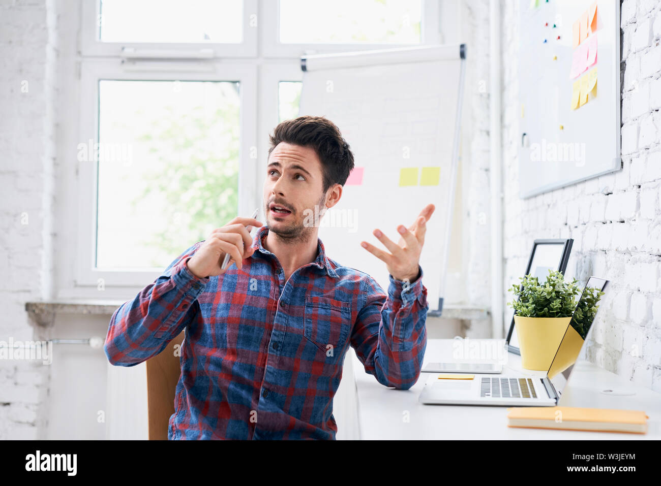 Junge Menschen sprechen, die auf dem Handy in Start-up-Büro Stockfoto