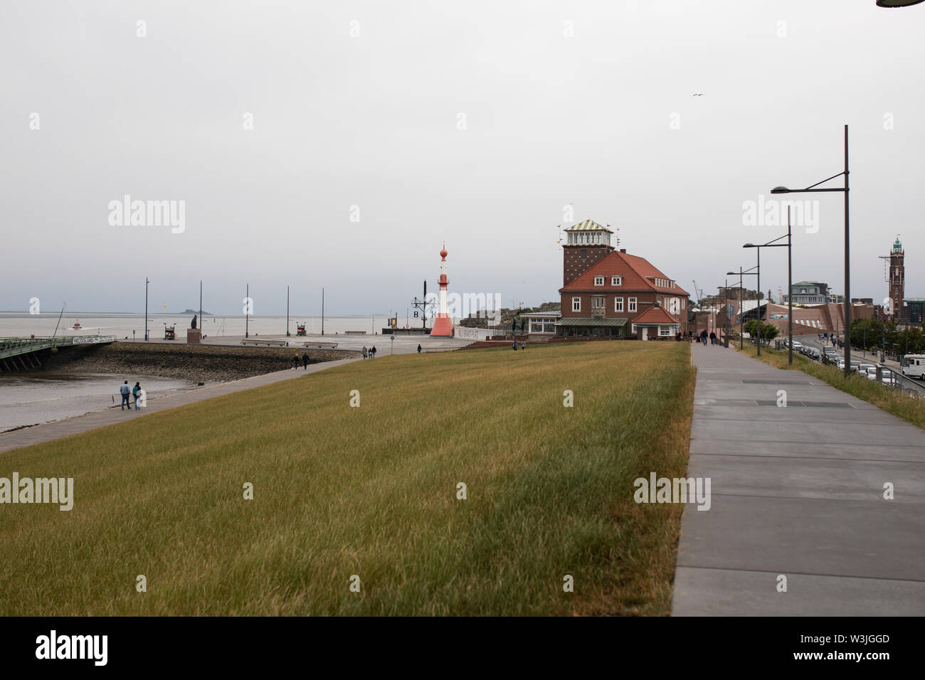 Bei einem Spaziergang entlang der Hafenpromenade in Richtung Leuchtturm am Willy Brandt Platz an einem bewölkten Tag in Bremerhaven, Deutschland, an der Nordsee. Stockfoto
