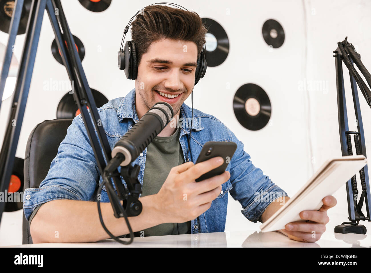 Schöne glückliche junge männliche radio Host Broadcasting im Studio, mit Mikrofon und Kopfhörer Stockfoto