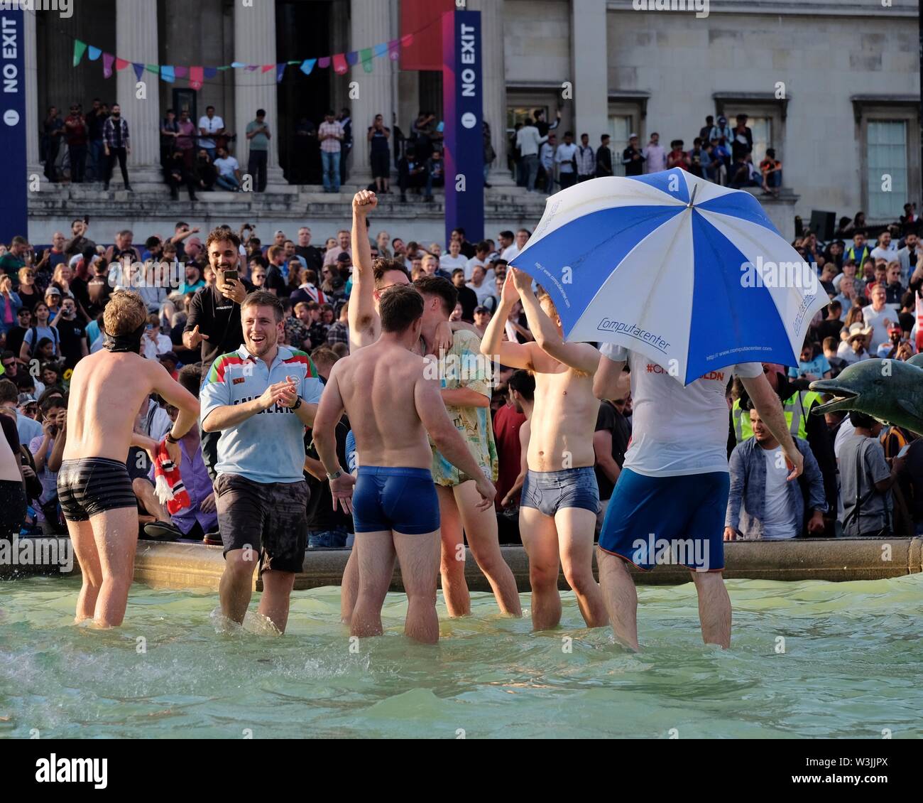 Cricket-Fans feiern den Sieg der englischen Weltmeisterschaft, indem sie in den Brunnen des Trafalgar Square eintauchen, wo das Finale live übertragen wurde. Stockfoto
