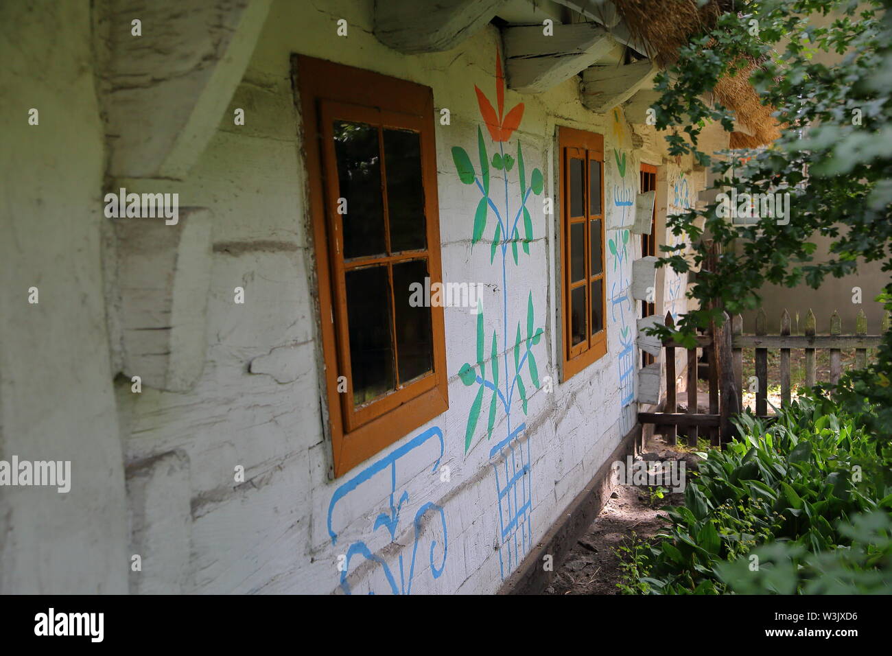 Traditionelle alte vintage Wooden House wunderschön mit floralen Mustern an den Wänden dekoriert, Garten vor, Windows, Polen. Stockfoto