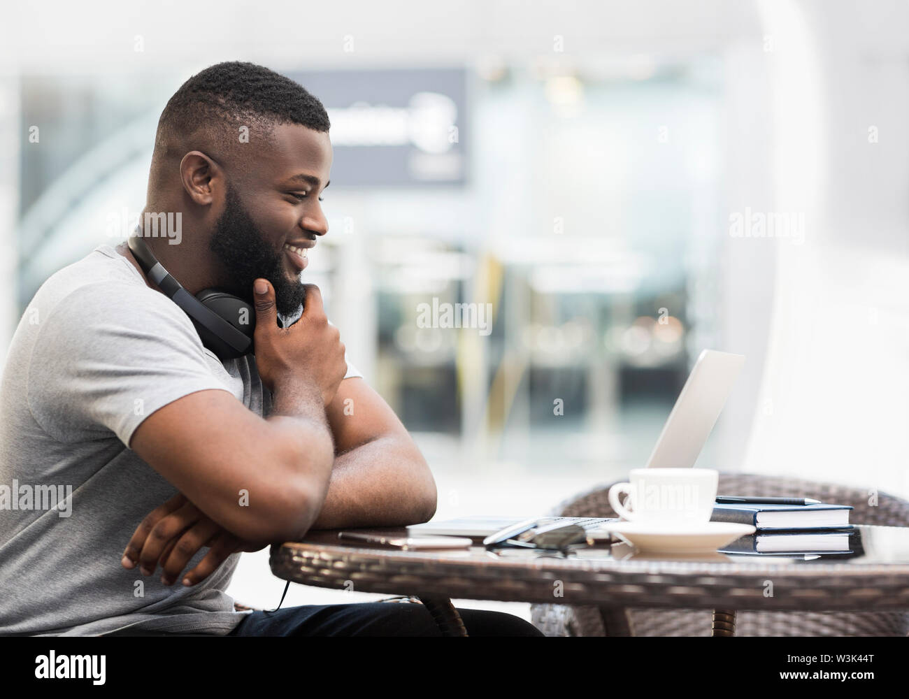 Fröhlich afrikanische amerikanische Mann gerade am Laptop Bildschirm Stockfoto