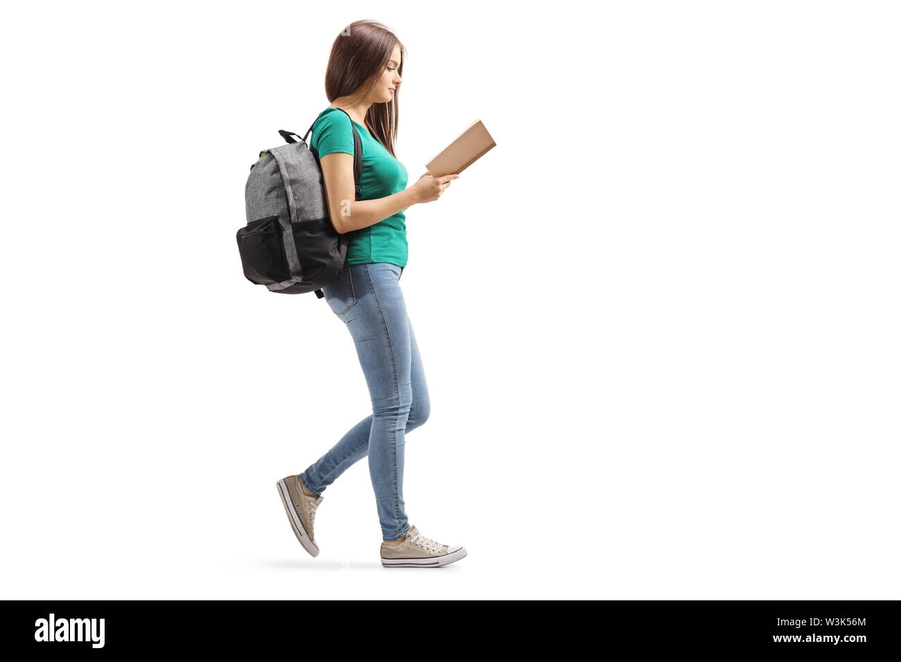 Volle Länge Profil Schoß einer Frau mit einem Rucksack ein Buch lesen und Wandern auf weißem Hintergrund Stockfoto