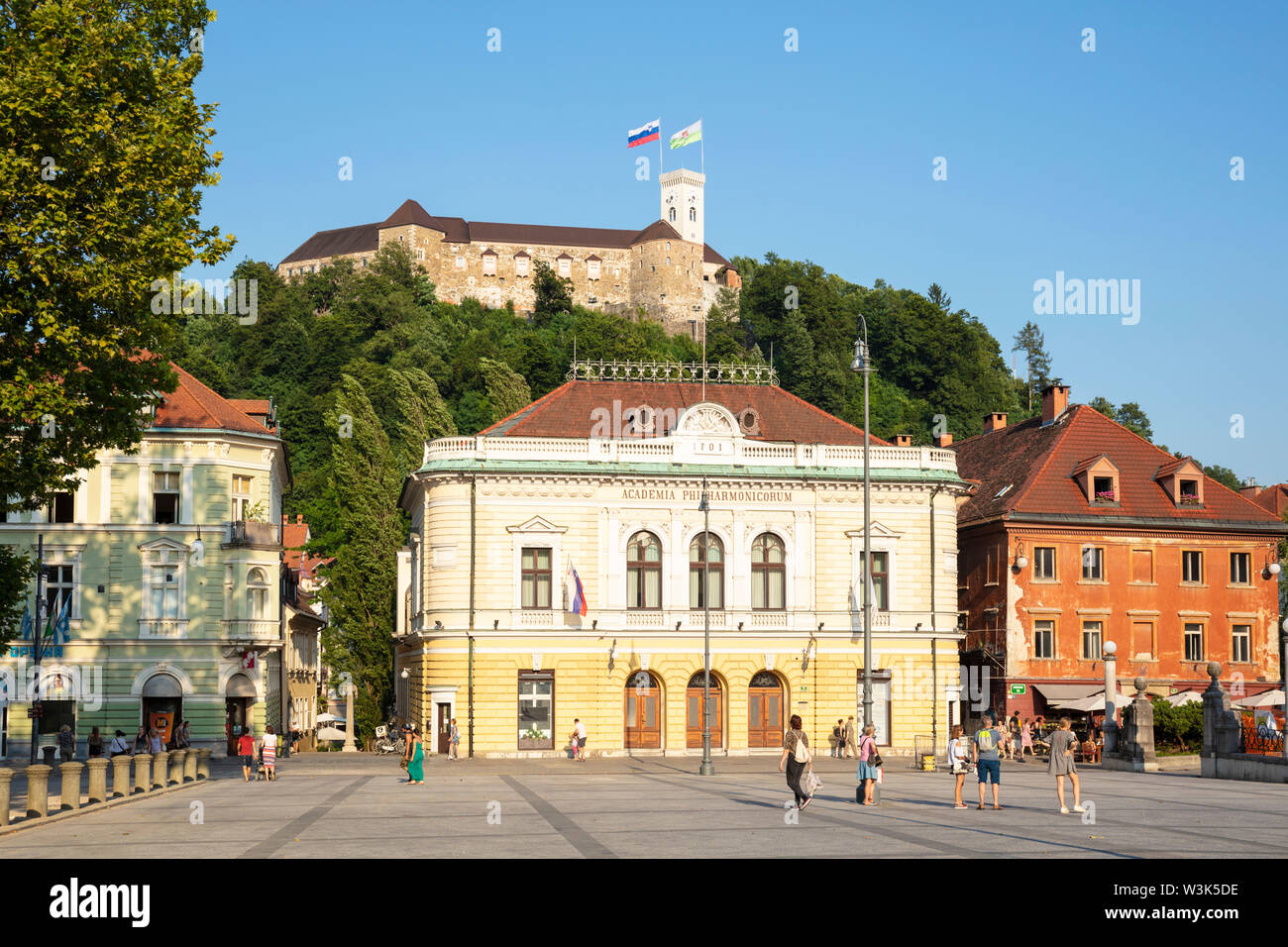 Die Burg von Ljubljana mit slowenischer Flagge hinter der Slovenska filharmonija Slowenische Philharmonie Gebäude Congress square Ljubljana Slowenien EU fliegen Stockfoto