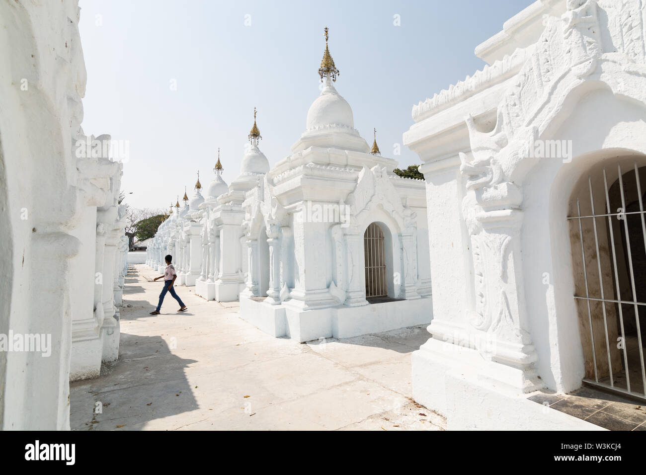 Mandalay, Myanmar - April 2019: Burmesische boy Silhouette läuft unter Stupas der Kuthodaw Pagode, die größte Buch der Welt Stockfoto
