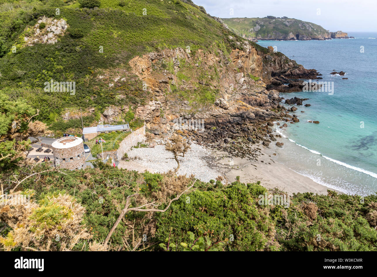 Auf der Suche nach unten von der Küste weg auf den Napoleonischen Schlupfloch Turm mit Blick auf Petit Bot Bay auf der schönen robusten Südküste von Guernsey UK Stockfoto