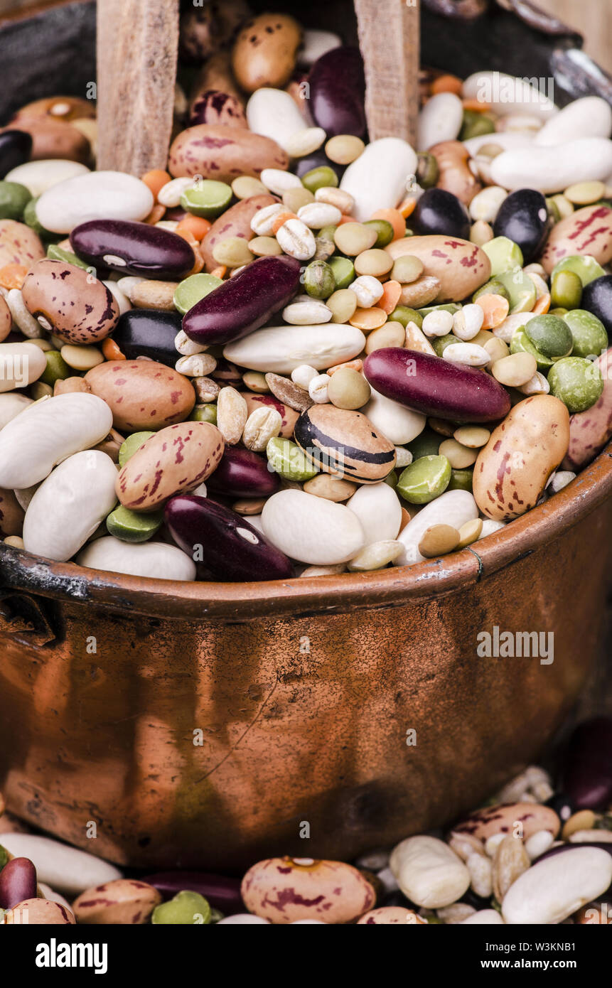 Hülsenfrucht Suppe und getrocknete Getreide gemischt in einem Kupfer Topf auf rustikalen Holztisch. Still Life Stockfoto