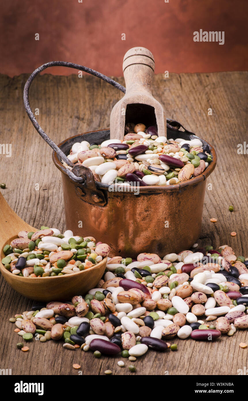 Hülsenfrucht Suppe und getrocknete Getreide gemischt in einem Kupfer Topf auf rustikalen Holztisch. Still Life Stockfoto