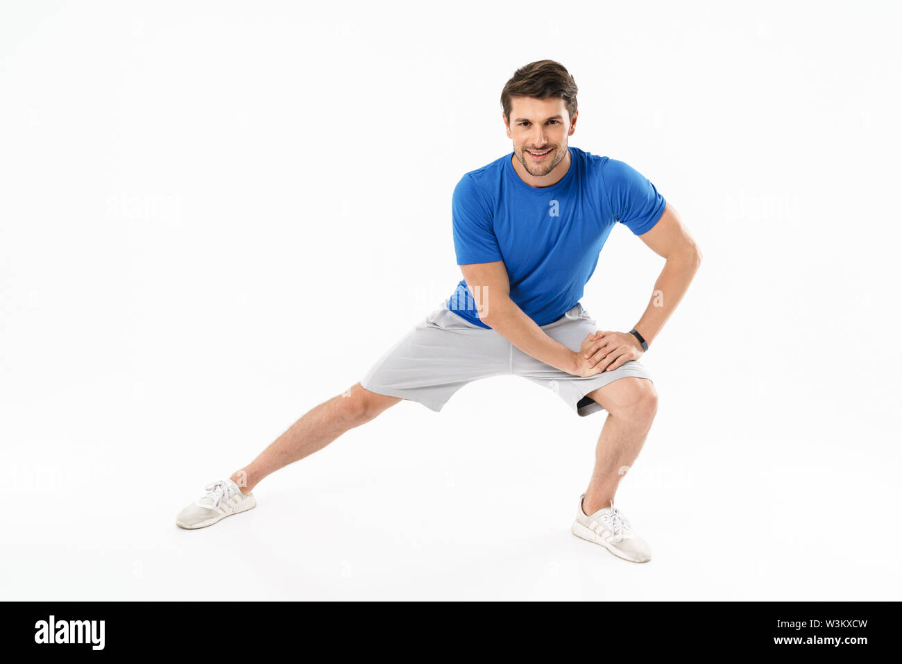 Foto von Muskel athletischer Mann in Shorts und T-Shirt, sportliche Übungen während der Arbeit aus isoliert auf weißem Hintergrund Stockfoto