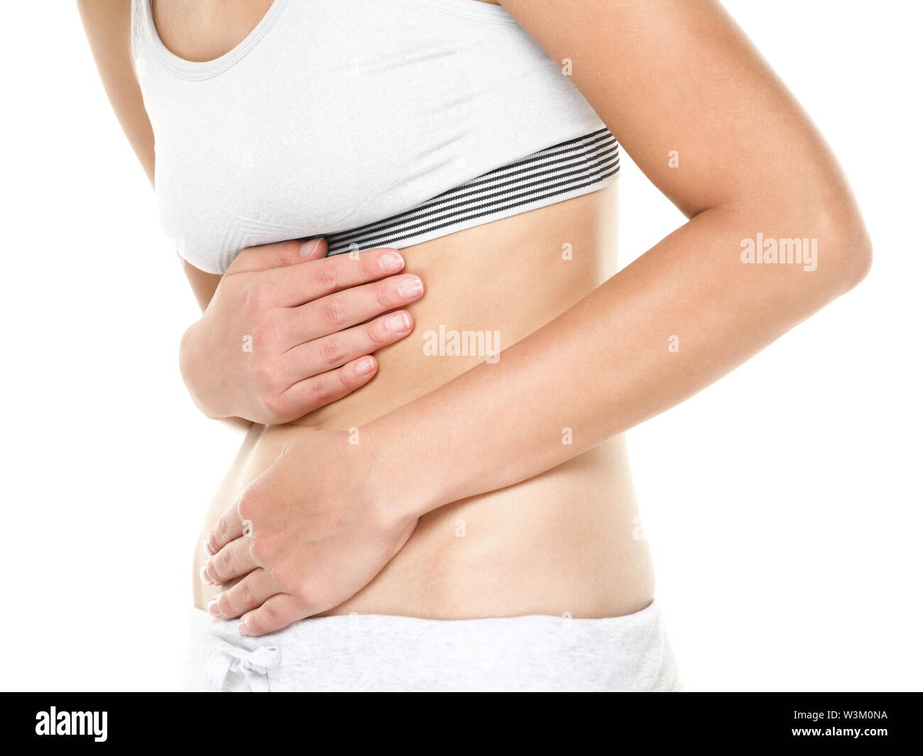 Magenschmerzen. Frau mit Bauchschmerzen Magenschmerzen oder Krämpfe. Nahaufnahme von jungen weiblichen Modell auf weißem Hintergrund. Stockfoto