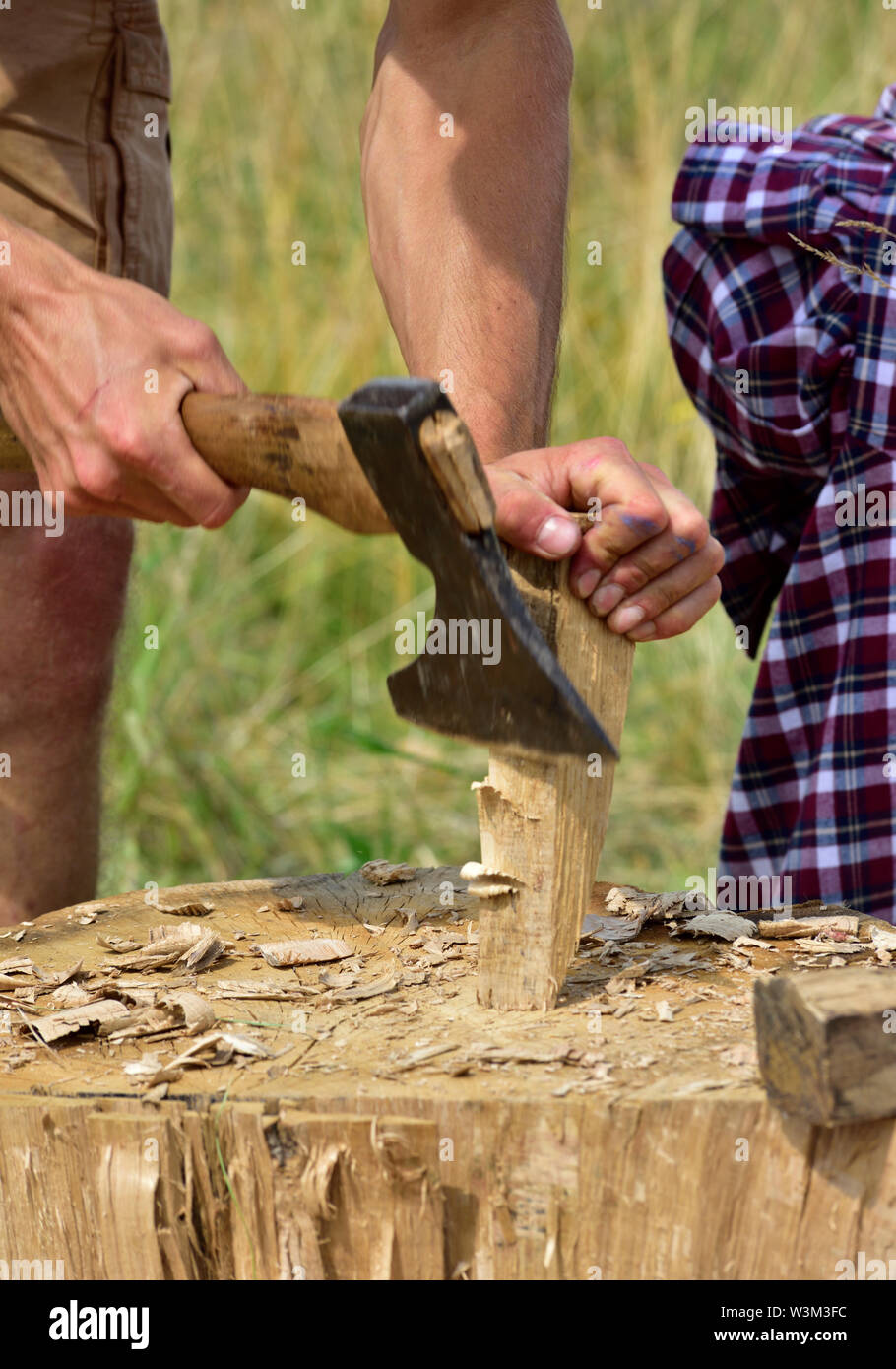 Mann mit Axt ein Holz keil in Teilen ein Protokoll verwendet werden Stockfoto