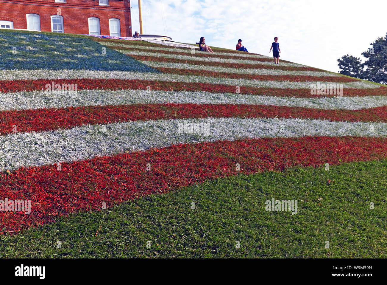 Eine riesige US-Flagge wird während der Feierlichkeiten im vierten Juli in einem Hügel im Fairport Harbour, Ohio, USA, gemalt. Stockfoto Eine riesige US-Flagge wird während der Feierlichkeiten im vierten Juli in einem Hügel im Fairport Harbour, Ohio, USA, gemalt. Stockfoto