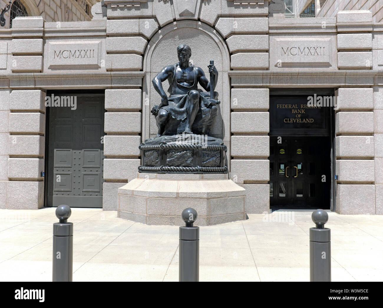 Die Cleveland Federal Reserve Enance on Superior Ave. Wird von der "Energy in Repose"-Statue von Henry Hering in Cleveland, Ohio, USA bewacht. Stockfoto