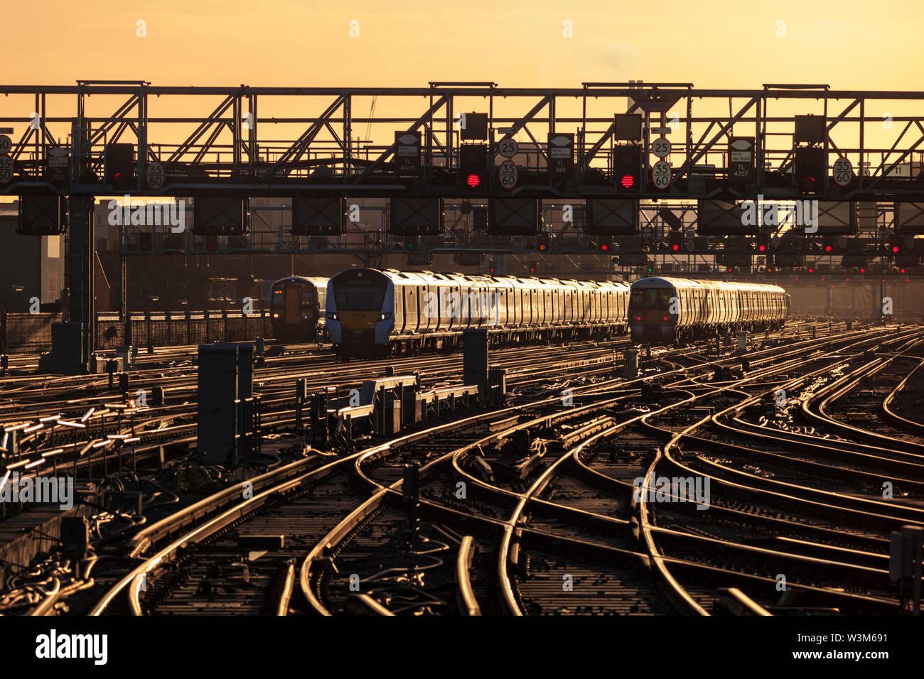 Süd- (GTR) und südöstliche Züge, die bei Sonnenaufgang von der Londoner Brücke kommend und abfahren, während der morgendlichen Londoner Pendlerzeit Stockfoto