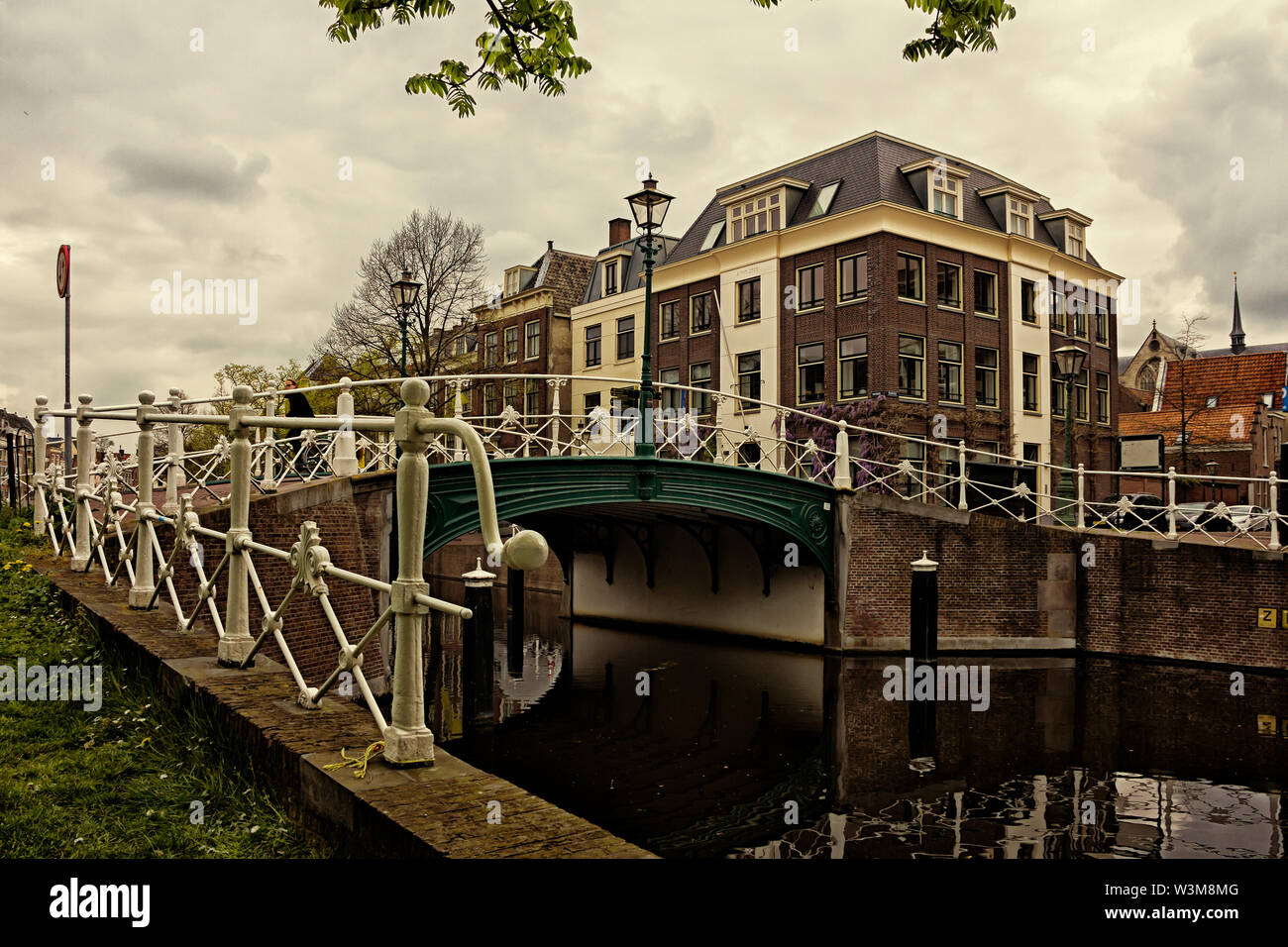 Leiden, Holland, Niederlande, April 18, 2019, eine Straße, Kanal in Leiden Altstadt, Nieuwsteebrug anzeigen. Magnolia Blumen, Boot auf dem Wasser. Stockfoto