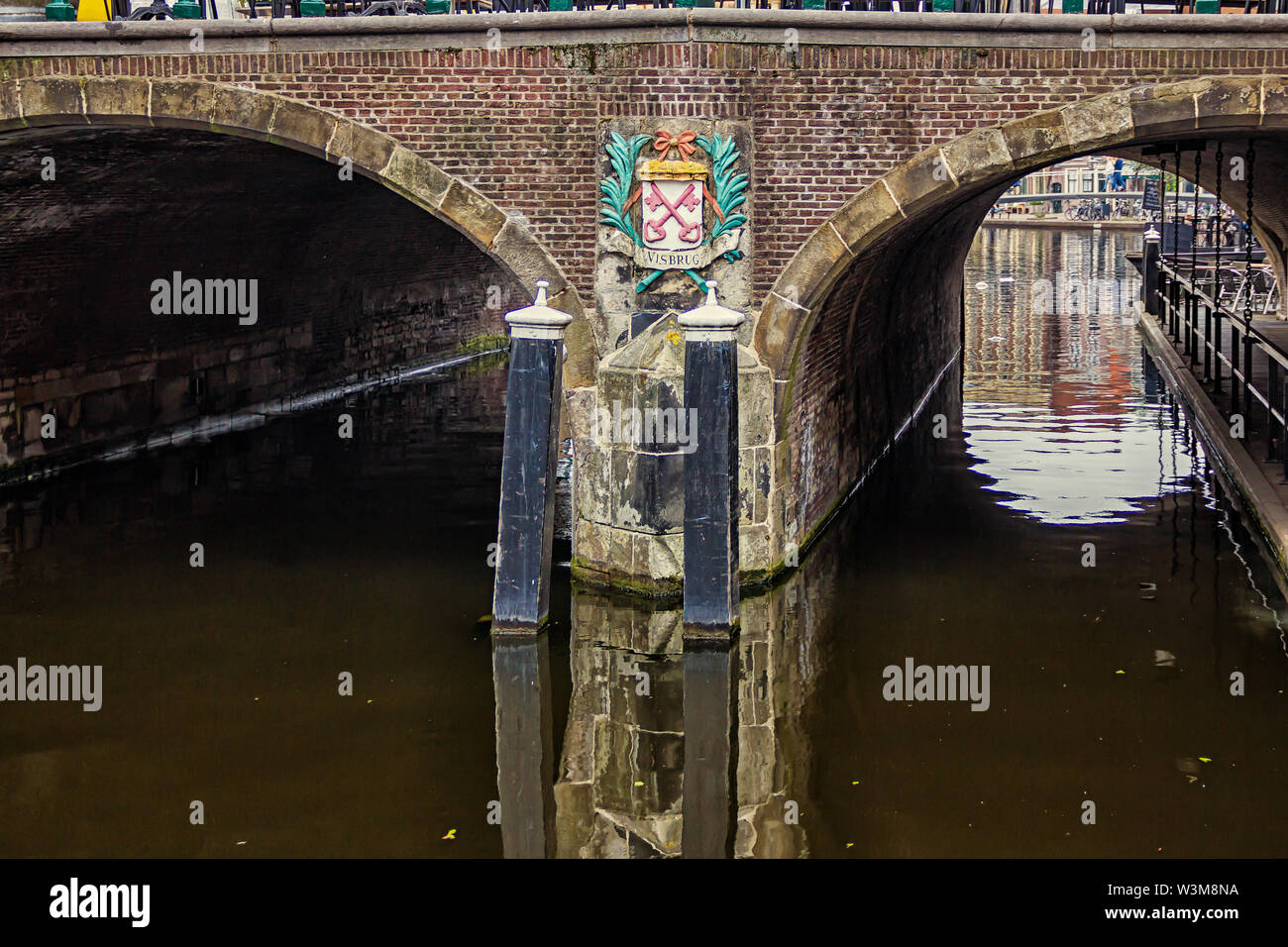 Leiden, Holland, Niederlande, April 18, 2019, Ansicht unter der Brücke Visbrug (Fisch), Säule mit dem Emblem von Leiden, Canal in Leiden Altstadt. Boote Stockfoto