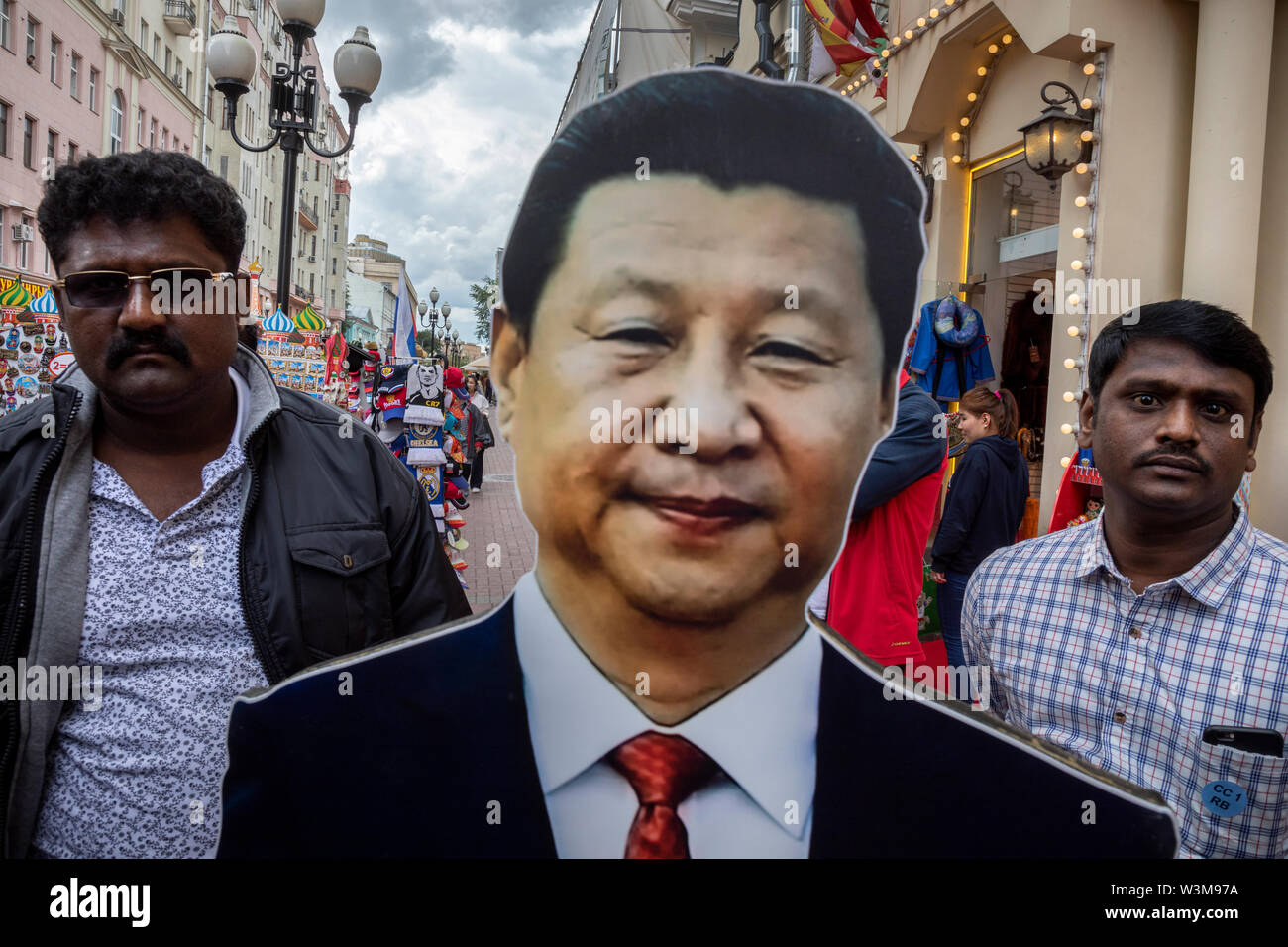 Touristen fotografiert gegen das Portrait der chinesischen Führer Xi Jinping auf Arbat Straße im Zentrum von Moskau, Russland Stockfoto