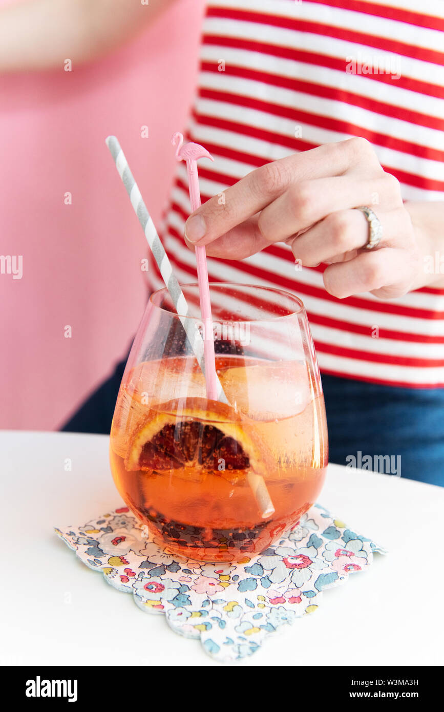 Frau mit Flamingo förmiges Rührwerk in cocktail Stockfoto