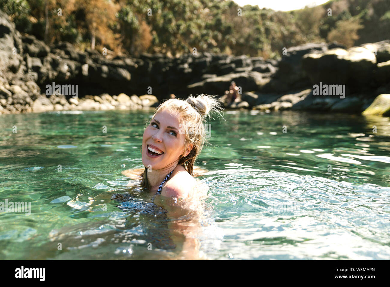 Lächelnde Frau schwimmen im Meer Stockfoto