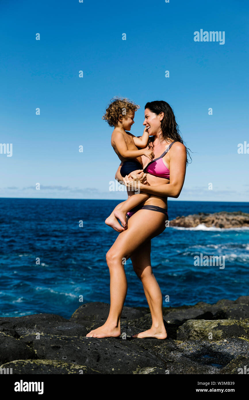 Die Mutter ihren Sohn auf den Felsen, Durchführung von Meer Stockfoto