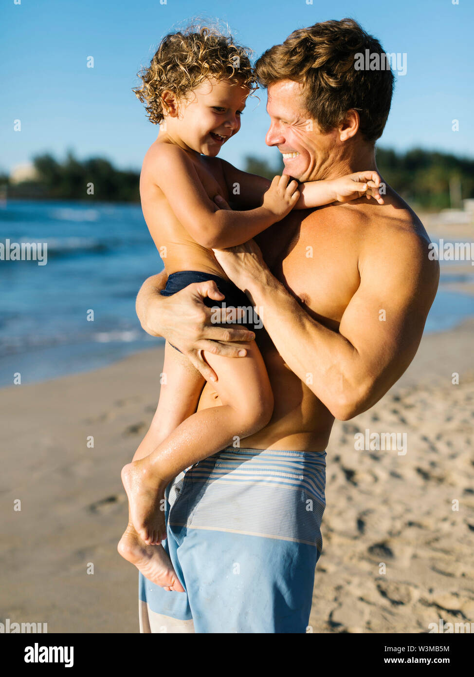 Mann spielt mit seinem Sohn am Strand. Stockfoto