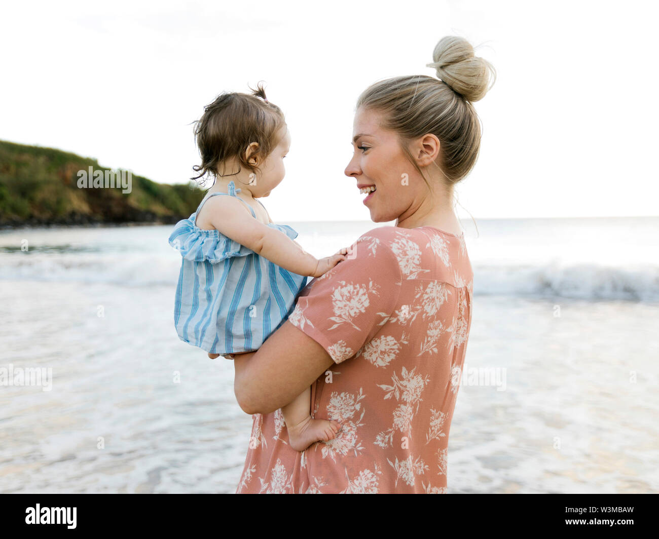 Frau mit Baby am Strand Stockfoto