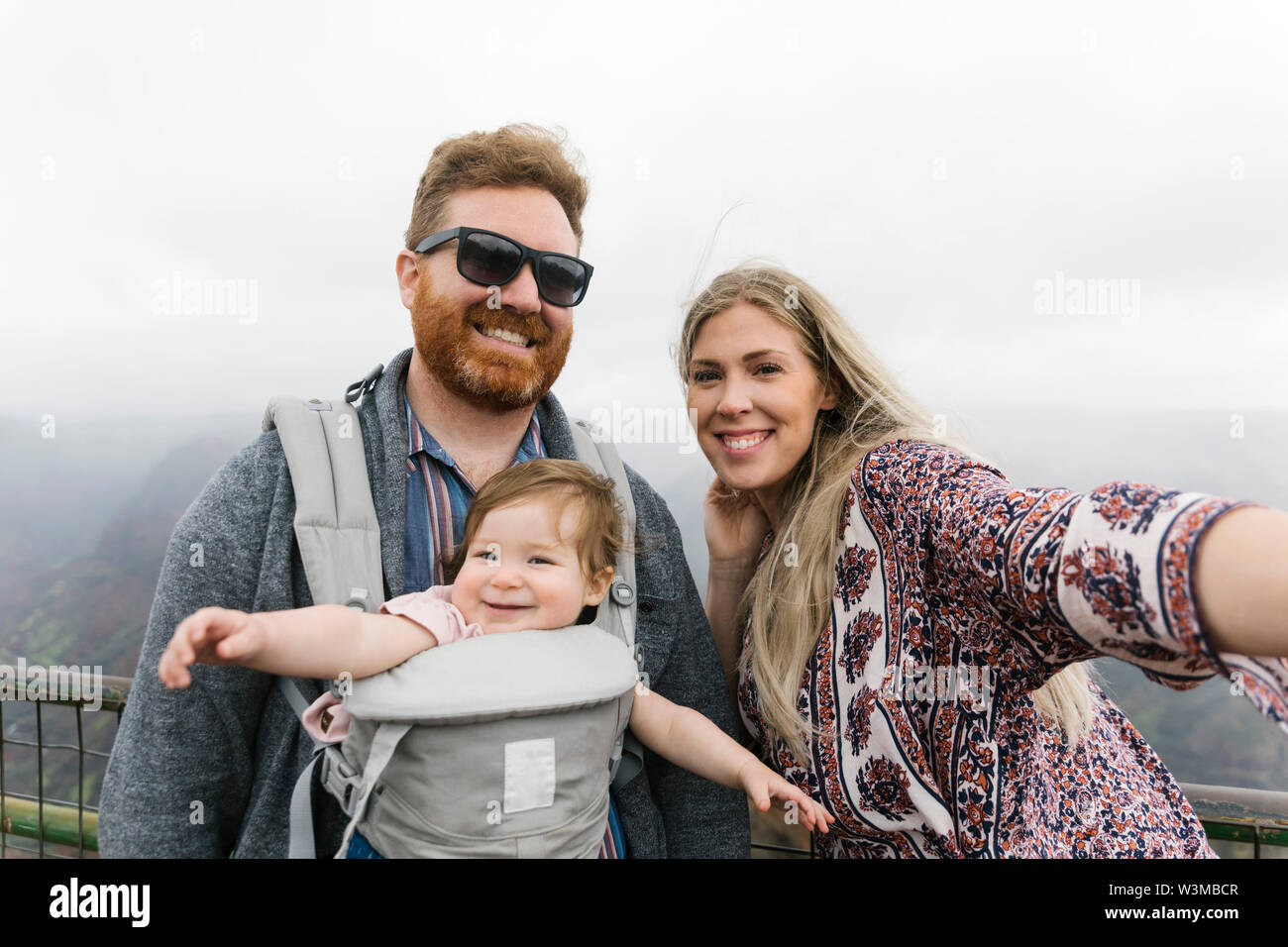 Eltern mit ihrem Baby Mädchen in Baby carrier Stockfoto