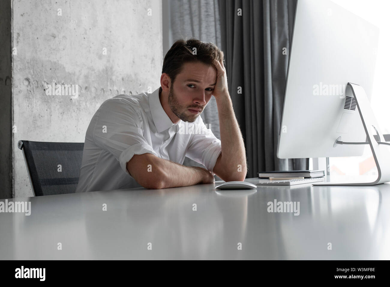 Deprimiert Geschäftsmann am Schreibtisch sitzen Stockfoto