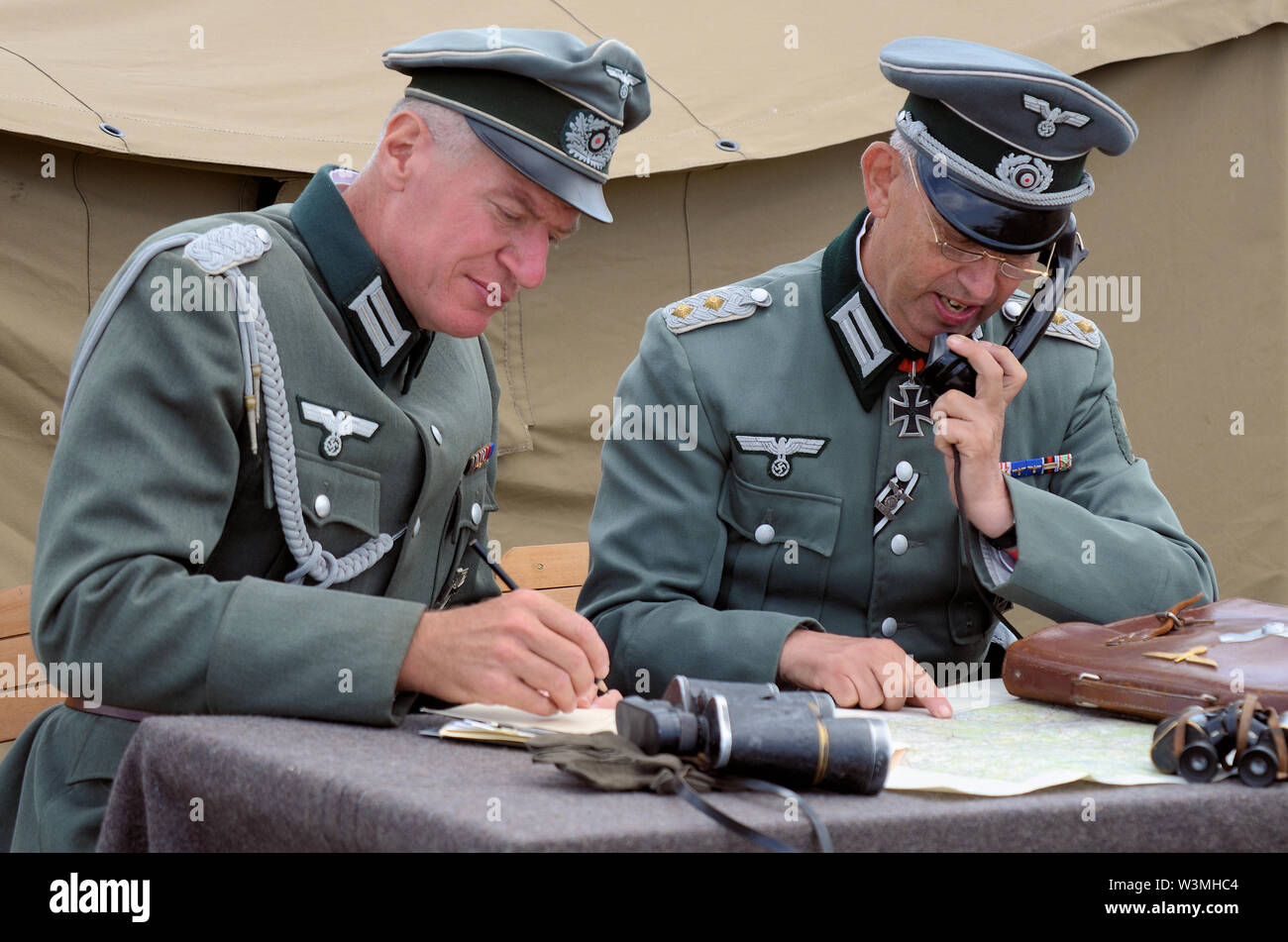 Zweiten Weltkrieg Re-enactors Deutscher Offizier in der Armee Soldaten Planung mit Karten und Kommunikation per Telefon dargestellt. Wehrmacht, Heer. Stockfoto