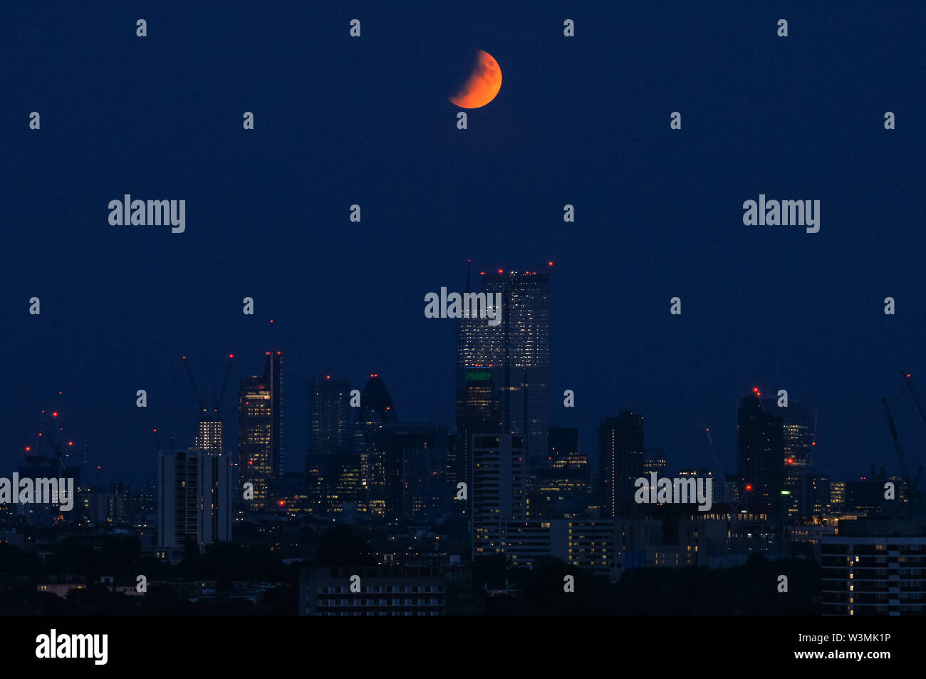 Der 'Buck Moon'-Vollmond, der über London aufsteigt. Eine partielle Mondfinsternis vom Parliament Hill in Hampstead Heath aus gesehen, London, England, Großbritannien, Großbritannien Stockfoto