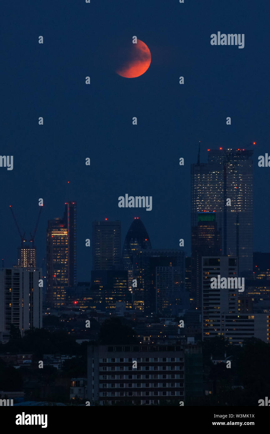 Der 'Buck Moon'-Vollmond, der über London aufsteigt. Eine partielle Mondfinsternis vom Parliament Hill in Hampstead Heath aus gesehen, London, England, Großbritannien, Großbritannien Stockfoto