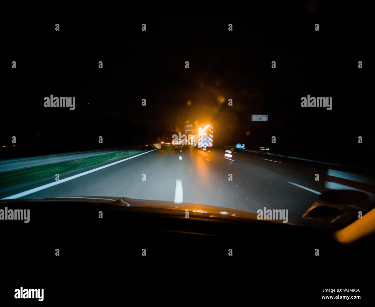 Treiber POV auf der dunklen Autobahn mit Unfall Baustellen und gelb blinkenden Pfeil Stockfoto