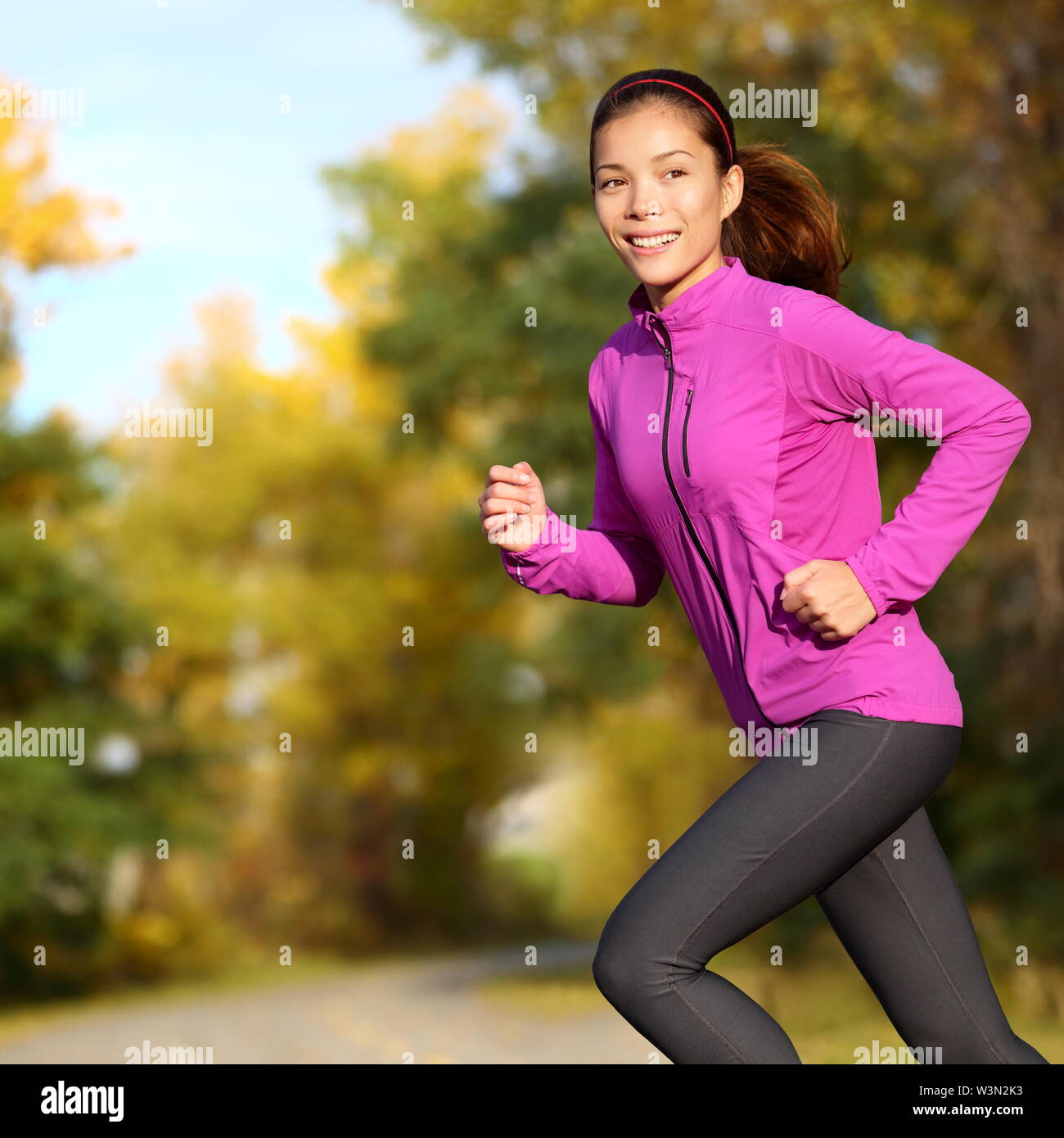 Junge asiatische Frau mit weiblichen Jogger glücklich. Läuferin Jogging im Park im Herbst Park Wald im Herbst Farben. Schöne junge Sport Modell. Multi-ethnischen asiatische Chinesische/Kaukasische Mädchen in ihrem 20. Stockfoto