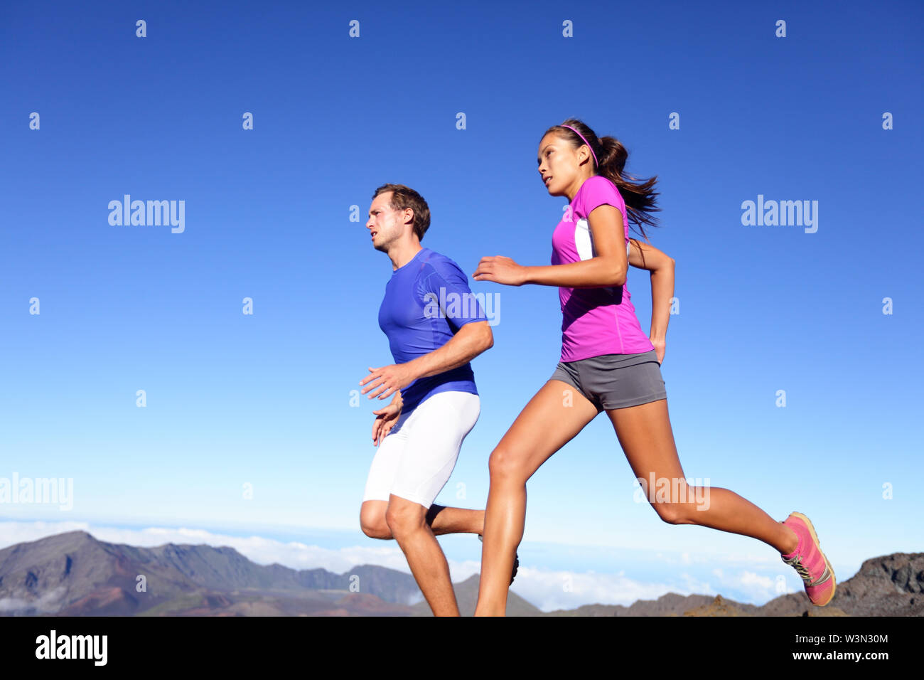 Ausführen von Menschen - Läufer Training Outdoor. Junge sport Athleten paar Sprinten als Teil eines gesunden Lebensstils. Passen gemischtrassiges Paar asiatische Frau und kaukasische Sport Modell in atemberaubender Natur. Stockfoto