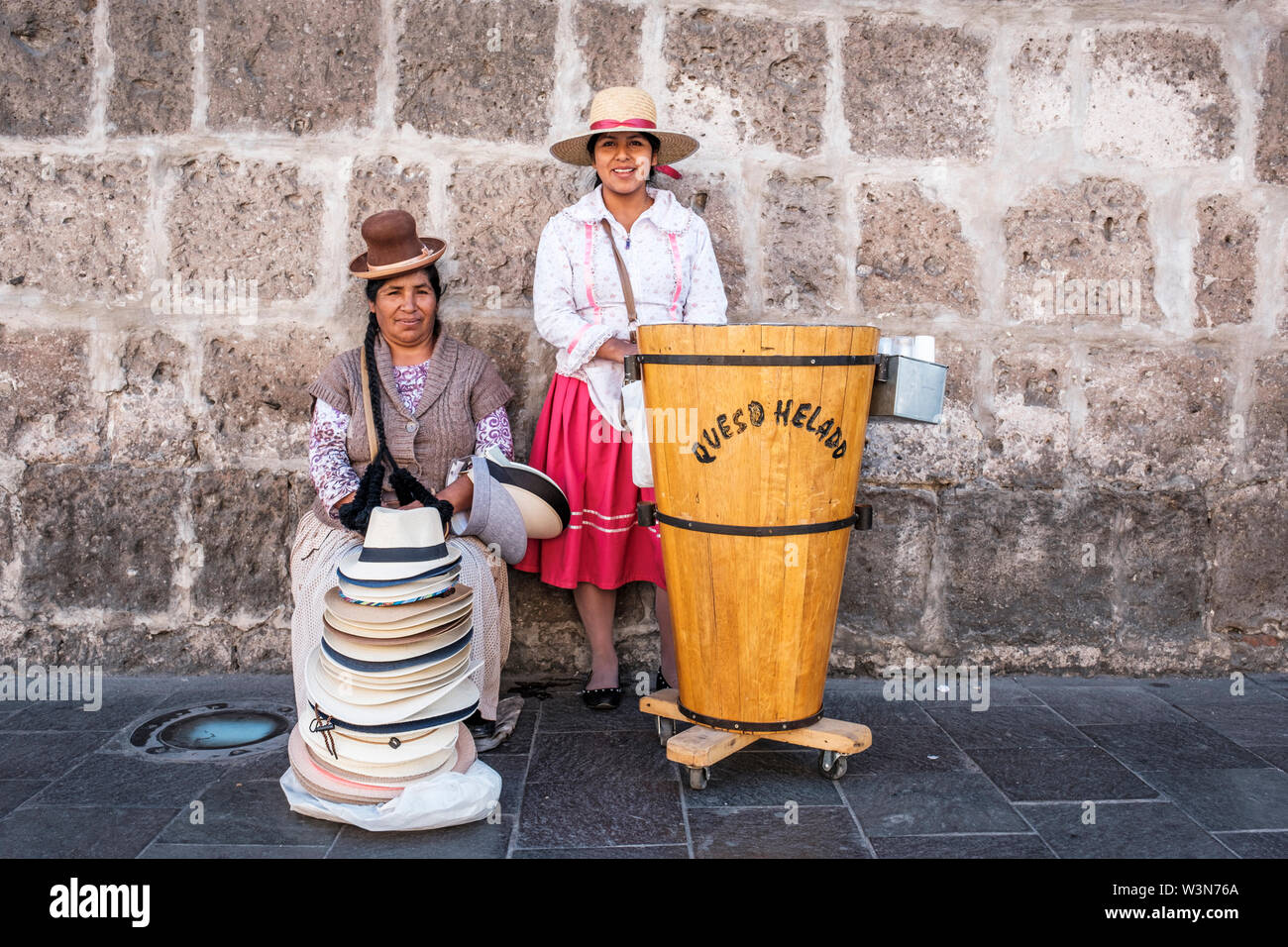 Straßenhändler. Porträt peruanischer Frauen, die Queso Helado (Käseeis) und Hüte in traditioneller peruanischer Kleidung verkaufen, Arequipa, Peru. Stockfoto