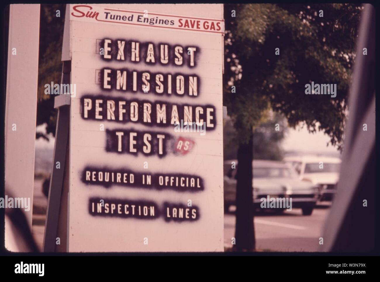 Nahaufnahme eines Zeichens auf eine von mehreren Tankstellen, die Annoncieren Tuneups, Emissionen und Sicherheit Tests... 08-1975 (4265800263). Stockfoto