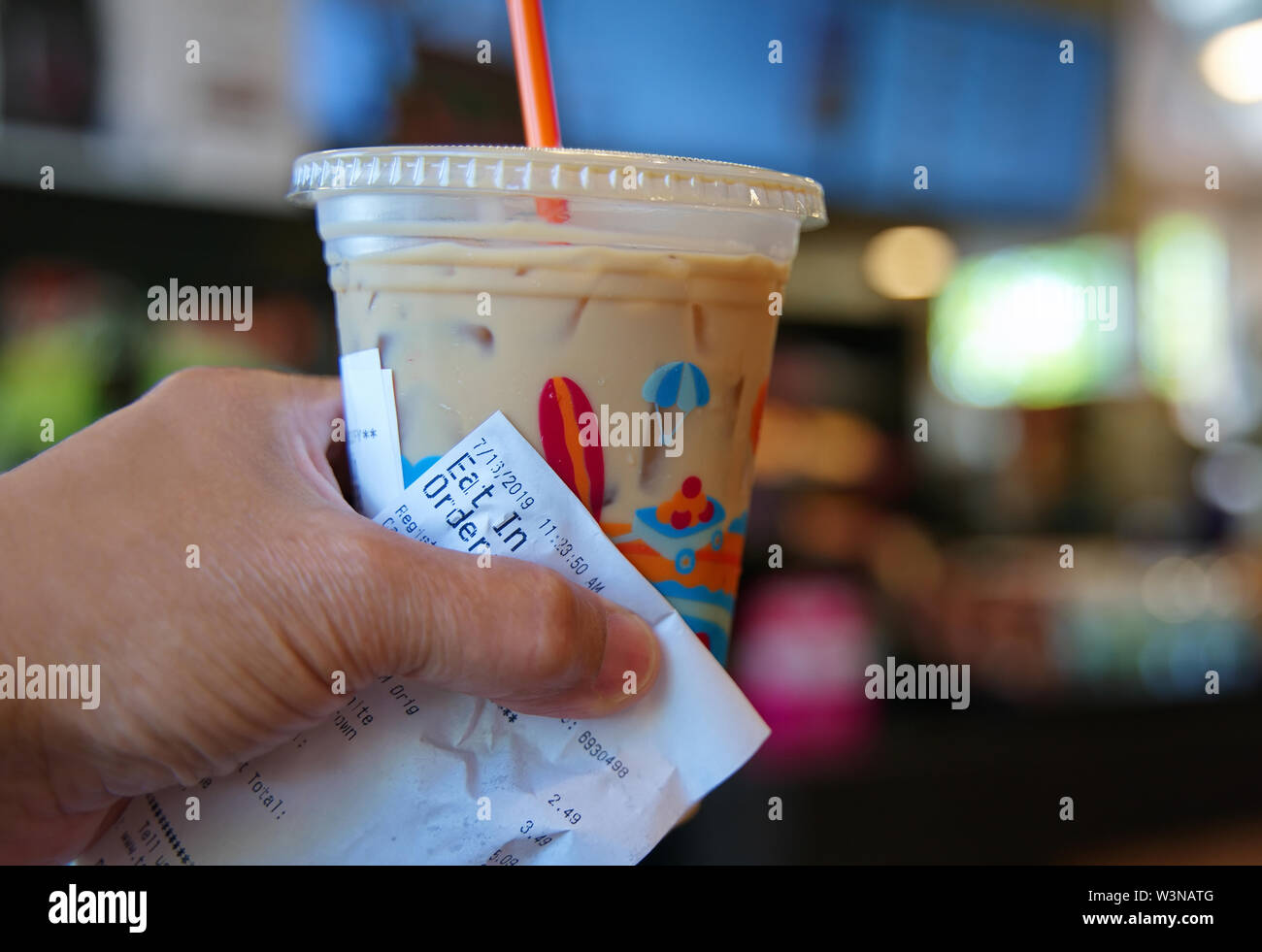 Der Kunde hand mit einem kalten Kaffee und Empfang warten auf weitere Aufträge zu kommen. Stockfoto