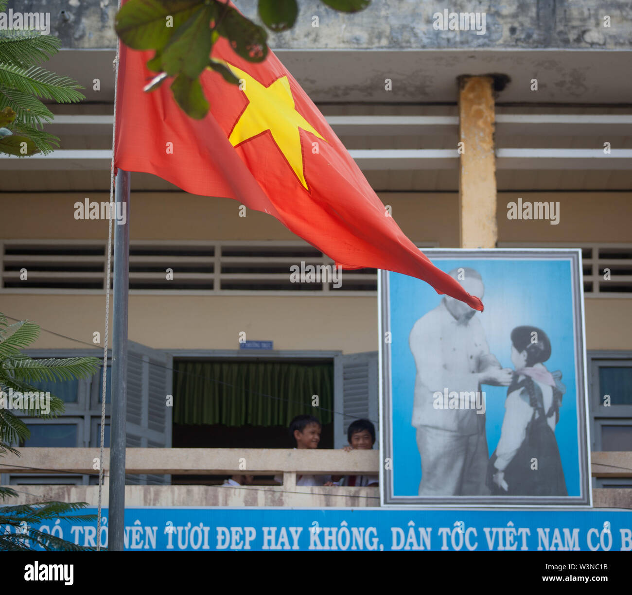 Studenten an ihrer Schule, Kien Phouc Schule in Tien Giang Provinz; ausserhalb von Ho Chi Minh City, Vietnam in Asien hinter einem grossen Foto von Ho Stockfoto