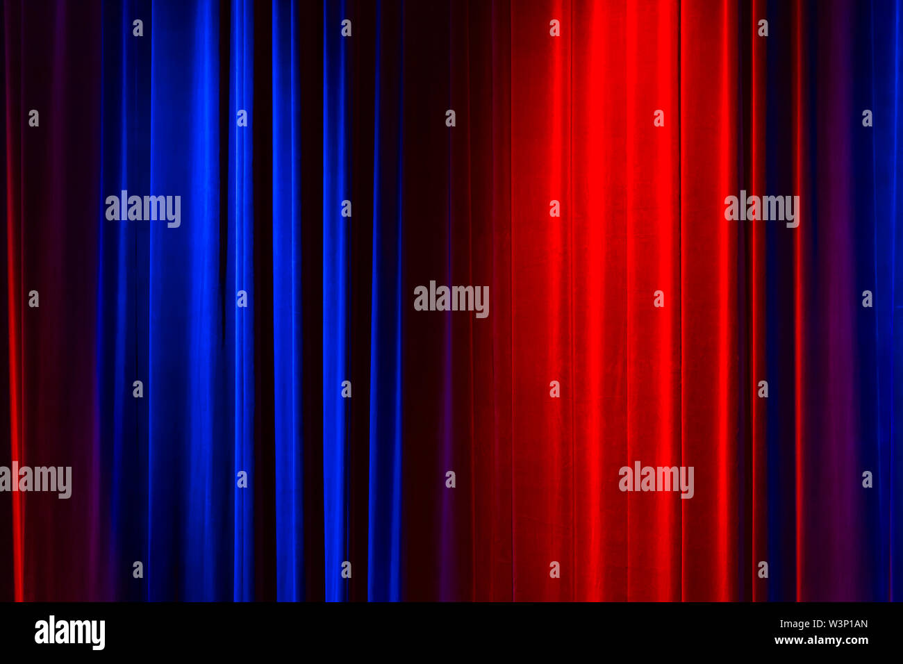 Vorderansicht eines geschlossenen Vintage Style velvet Theater Vorhang durch eine rote und eine blaue Scheinwerfer beleuchtet Stockfoto