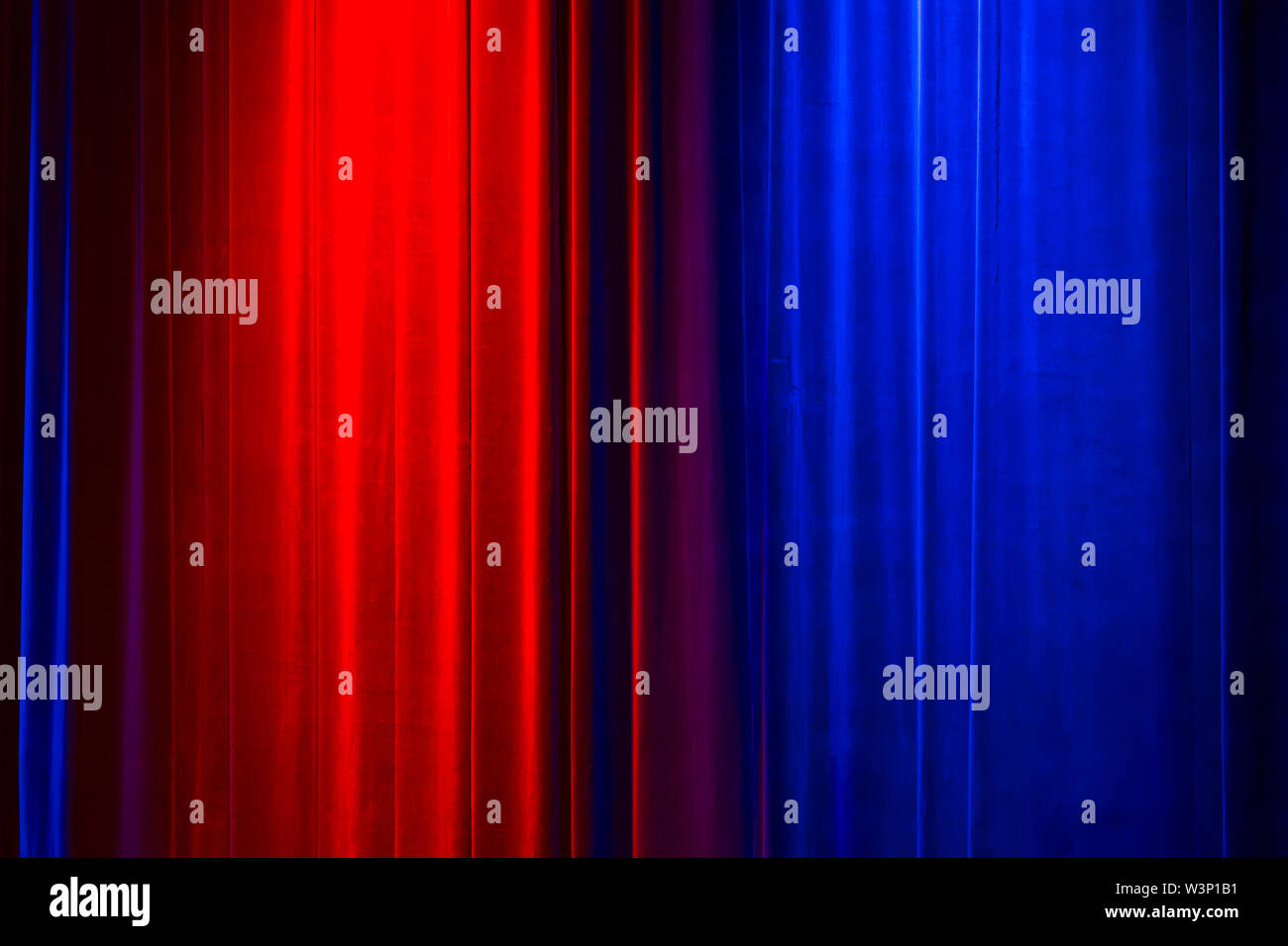 Vorderansicht eines geschlossenen Vintage Style velvet Theater Vorhang durch eine rote und eine blaue Scheinwerfer beleuchtet Stockfoto